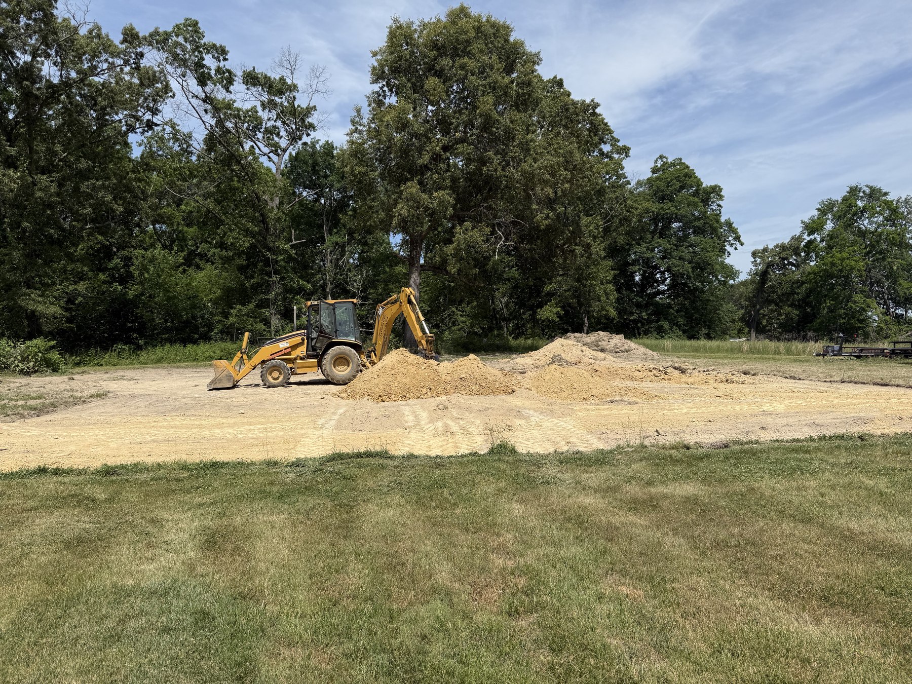 Backhoe grading and clearing a home site